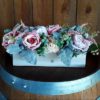 Faux pink flowers in a wooden box