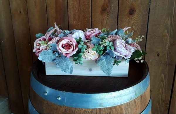 Faux pink flowers in a wooden box